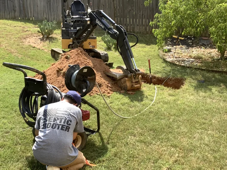 SepticRooter tech on site with excavator working a septic call