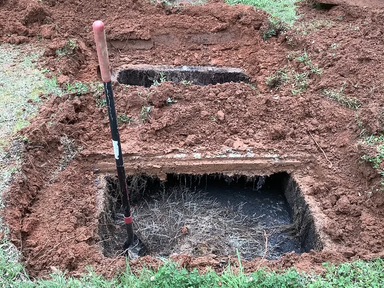 Excavated septic tank access opened and ready for service